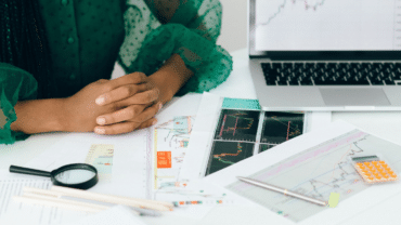 a person sitting with charts and a laptop